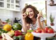 Woman holding a slice of cucumber
