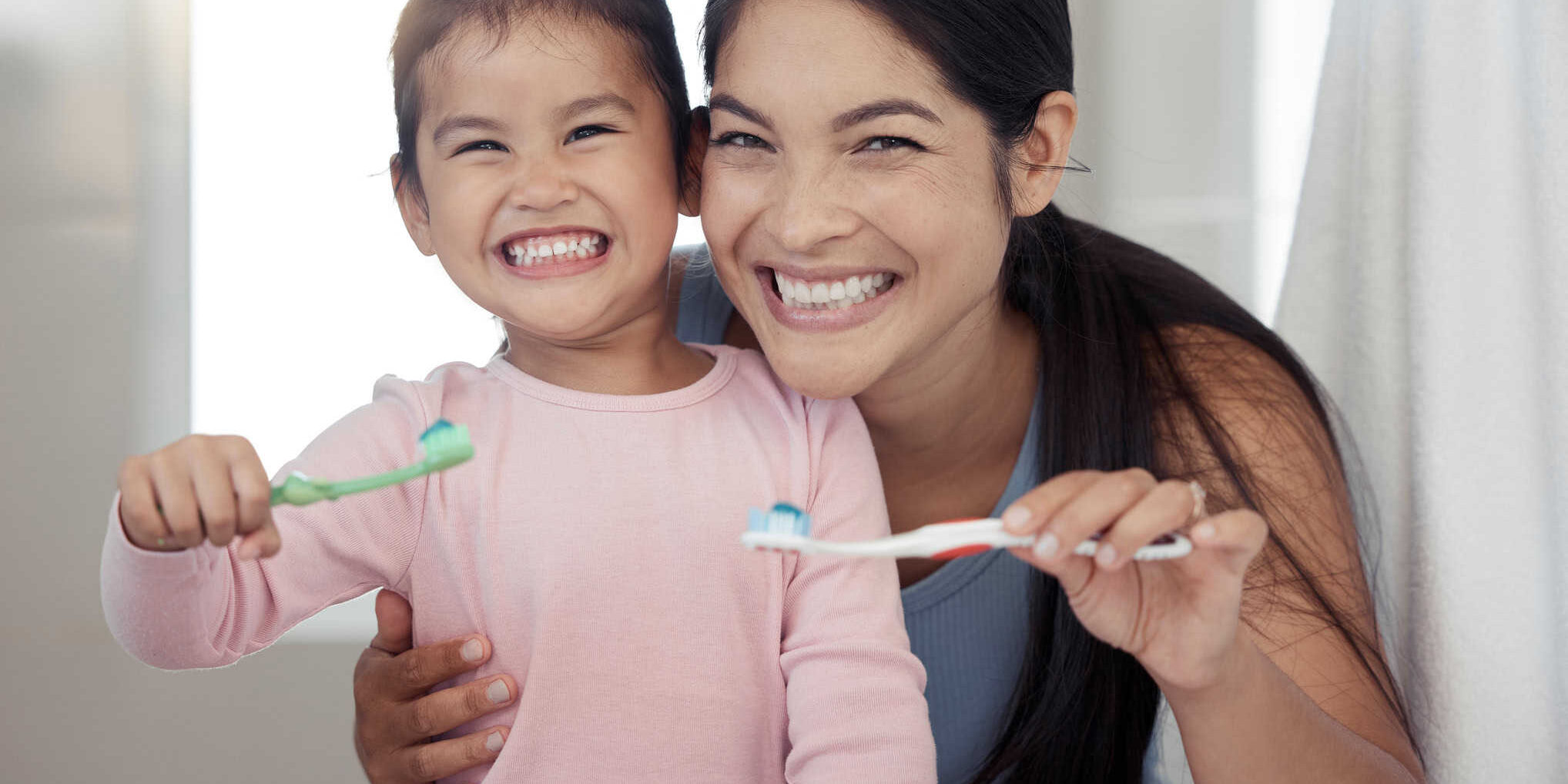 Portrait of mom and kid brushing teeth, dental healthy and cleaning in bathroom at home. Happy mother and girl learning oral healthcare, wellness and fresh breath for toothbrush, toothpaste and smile