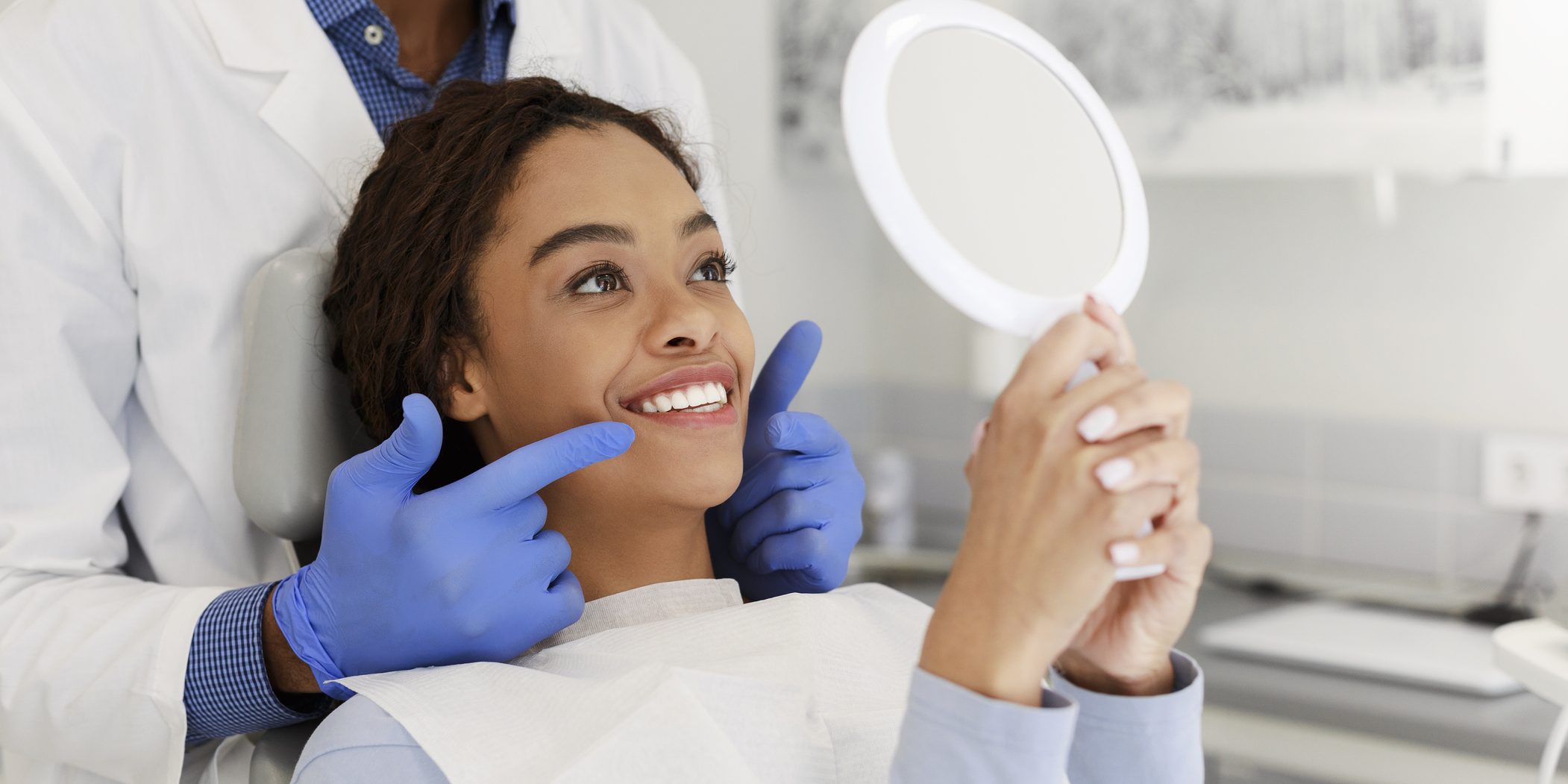 Attractive lady checking her beautiful smile in mirror